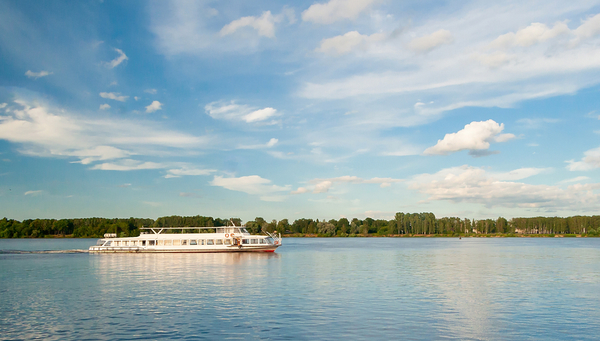 A tourist boat sailing down the river Rhine on a clear summer day.
